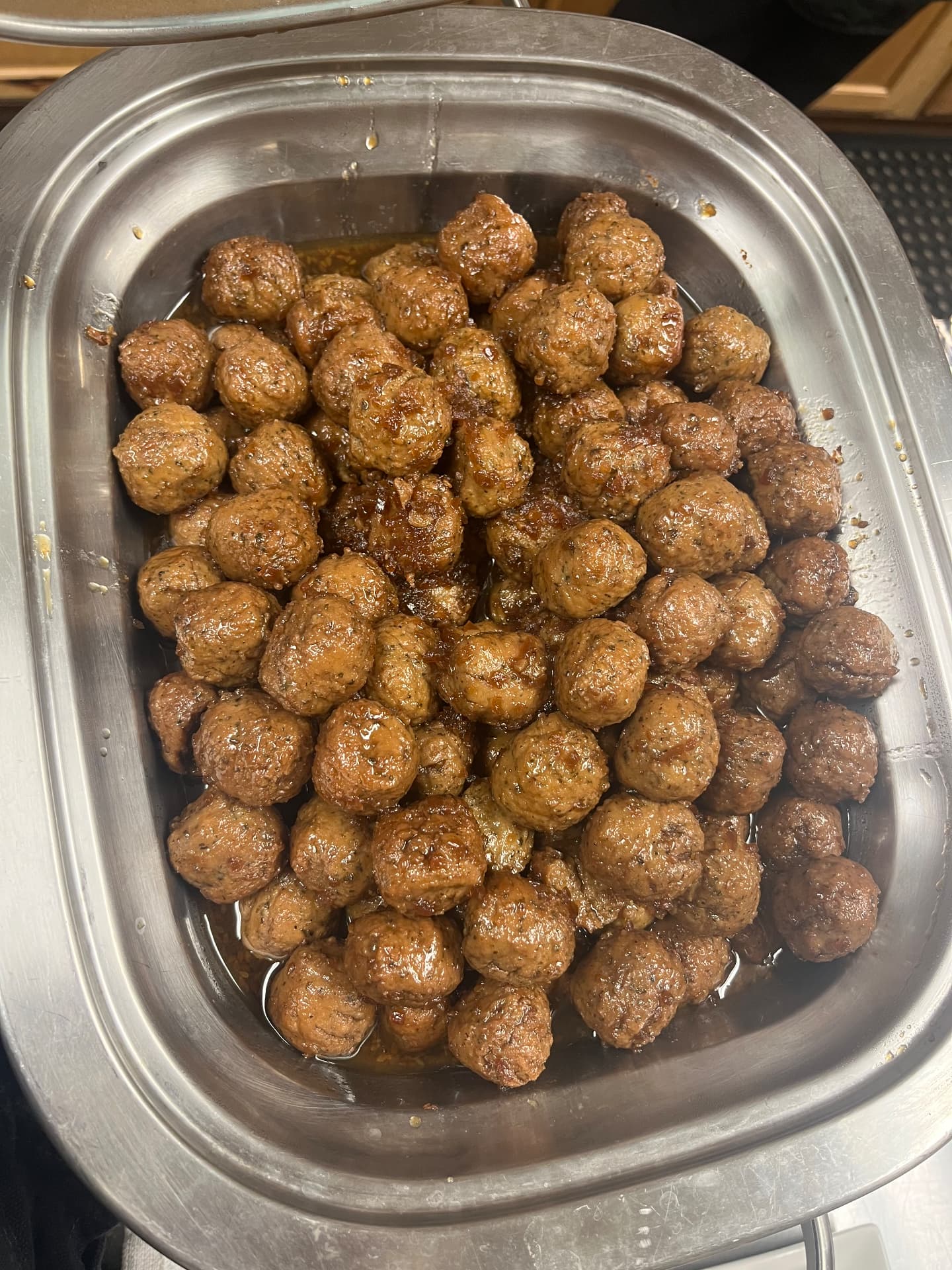 Glazed cocktail meatballs in a chafing dish