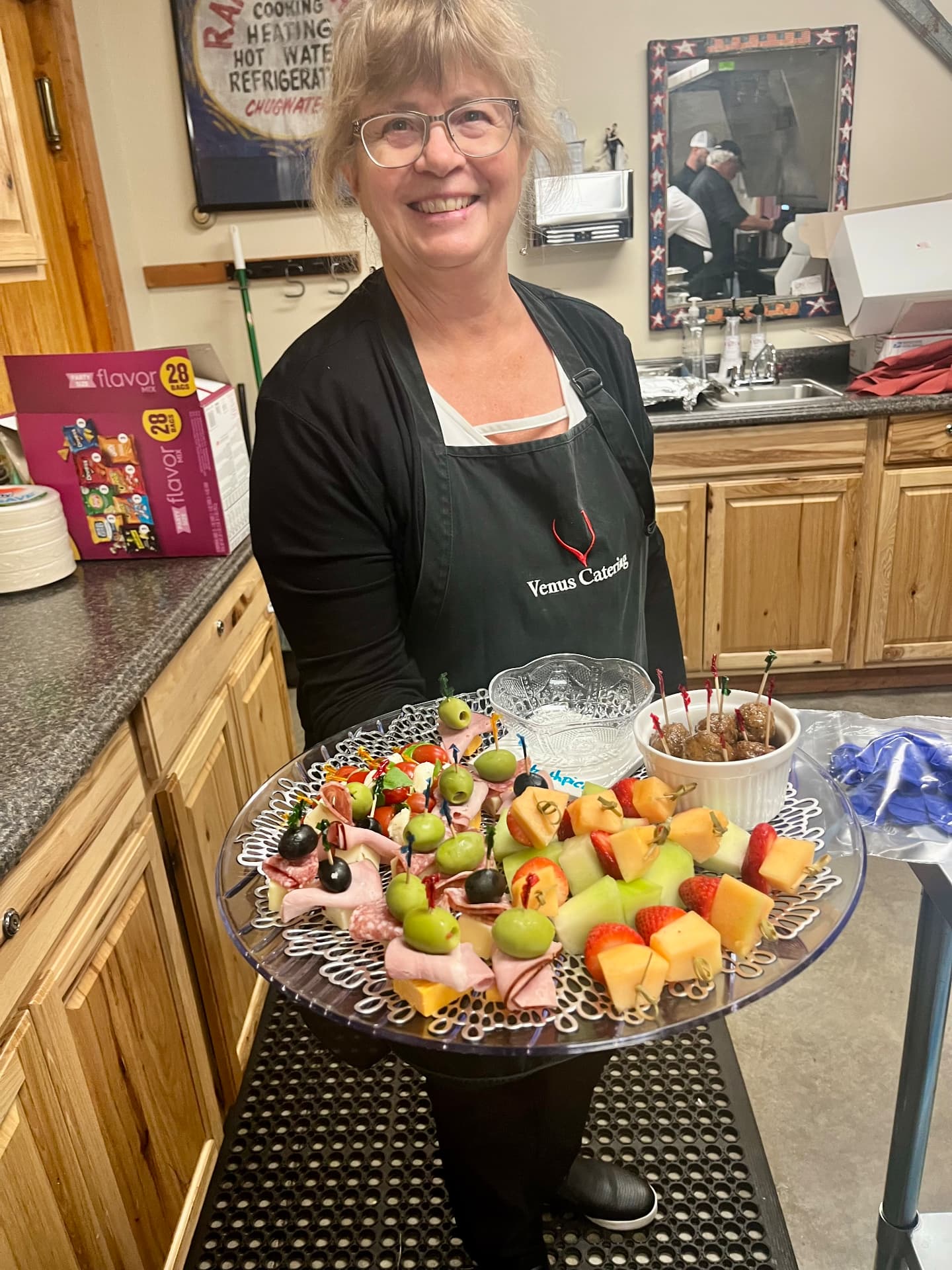 Laurie Rolsma smiling in her kitchen with a tray of passed appetizers